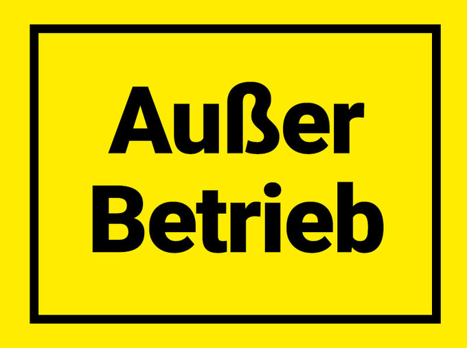 Gelbes Warnschild mit schwarzem Rahmen und der Aufschrift „Außer Betrieb“.
